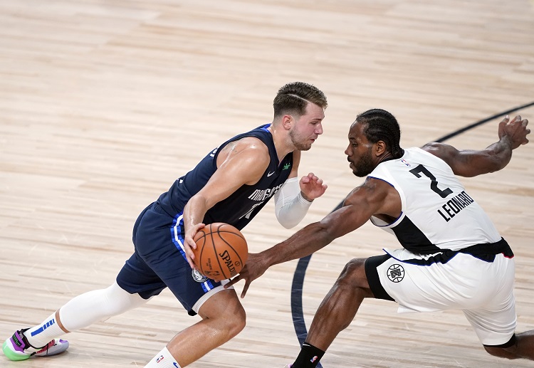 Luka Doncic trying to shoot the ball against Kawhi Leonard during the second half of an NBA match